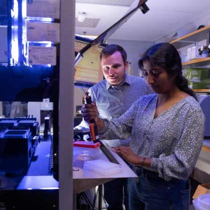 Male professor works with undergraduate female student in a biomedical engineering lab.
