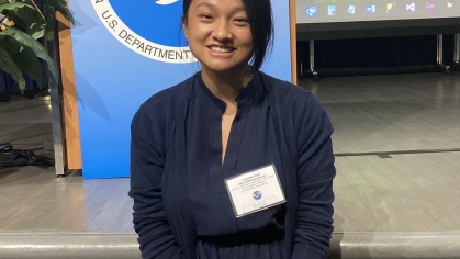 Female Asian college student wearing a navy blue dress and a name tag.