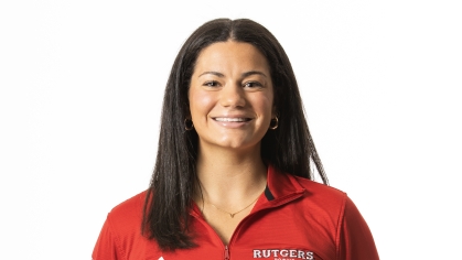 Female college student poses from the waist up with her hands behind her back. She has long black hair and is wearing red Rutgers pulloever.