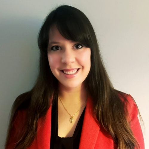 head shot of woman with long brown hair and bangs wearing a red suit jacket with a black blouse