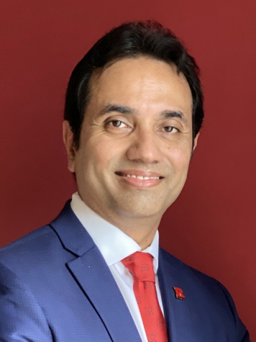 Head shot of Asian male with short black hair wearing a blue suit jacket, a white button down shirt, and a red tie.