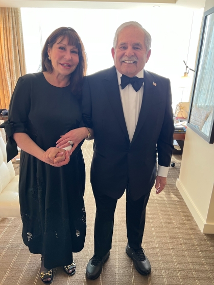 woman in long black dress standing next to an elderly man wearing a black tuxedo with a bow tie and white shirt