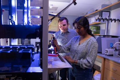 Male professor works with undergraduate female student in a biomedical engineering lab.