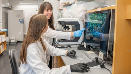Two women in a lab looking at a monitor.
