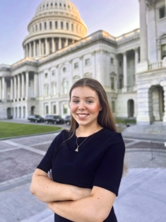 Photo of Katie Lynch standing in front of the US Capitol