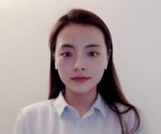 Headshot of Asian woman with long brown hair, wearing a pullover sweater with a white collared blouse underneath.